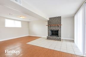 Saint Peters house for rent - a living room with a brick fireplace and wooden floors