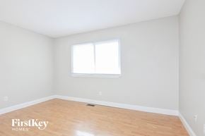 Saint Peters house for rent - a bedroom with white walls and wood floors and a window