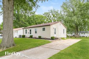 Florissant house for rent - a white house with green trees and a driveway