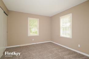 Florissant house for rent - the bedroom of a home with carpet and two windows