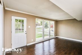 Florissant house for rent - the living room of a home with wood floors and a white door