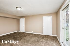 Florissant house for rent - a bedroom with a carpeted floor and a large window