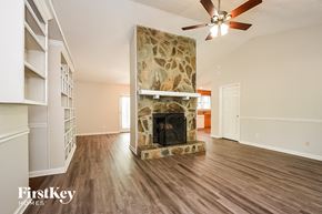 Kennesaw house for rent - A spacious living room with a stone fireplace and wood flooring.