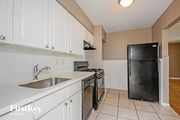 Saint Louis house for rent - A kitchen with white cabinets and a black refrigerator.
