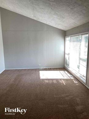 Addison house for rent - A room with a brown carpet and a window letting in sunlight.