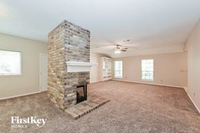 Spring house for rent - A room with a brick fireplace and a carpeted floor.