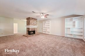 Spring house for rent - A living room with a fireplace and a ceiling fan.