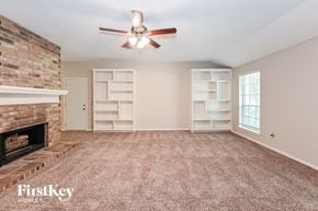 Spring house for rent - A room with a fireplace and a ceiling fan.