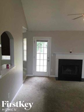 Covington house for rent - an empty living room with a fireplace and a white door