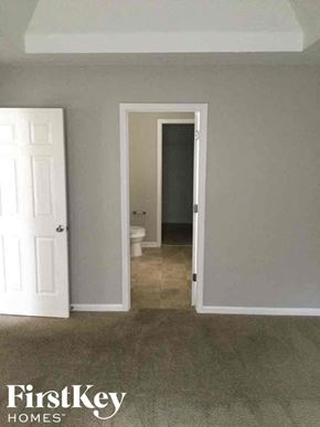 Covington house for rent - an empty room with a door open to a bathroom and a toilet
