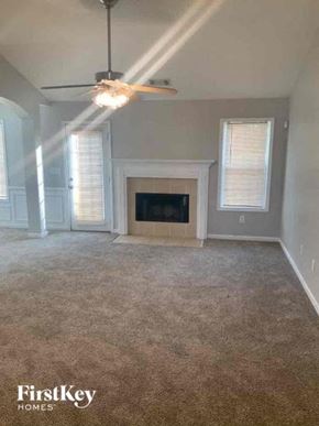 Covington house for rent - an empty living room with a fireplace and a ceiling fan