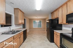 Covington house for rent - a kitchen with black appliances and wooden cabinets