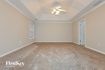 Covington house for rent - a spacious living room with carpet and a ceiling fan