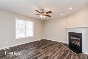 Fuquay Varina house for rent - a living room with a fireplace and a ceiling fan