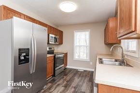 Fuquay Varina house for rent - a kitchen with stainless steel appliances and wooden cabinets