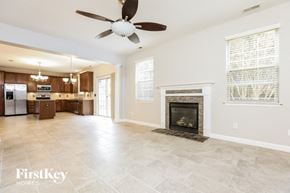 Clayton house for rent - A spacious living room with a fireplace and a ceiling fan.