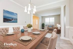 Clayton house for rent - A dining room with a wooden table set for a meal.