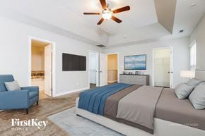Clayton house for rent - A bedroom with a large bed and a ceiling fan.