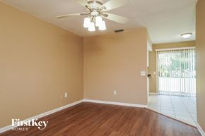 North Fort Myers house for rent - A room with a ceiling fan and light fixture, and a door leading to a balcony.