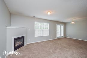 Covington house for rent - A living room with a fireplace and a carpeted floor.