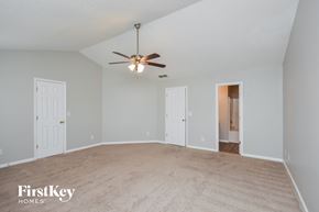 Covington house for rent - A spacious room with a ceiling fan and beige carpeting.