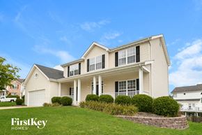 O'fallon house for rent - A large house with a well-manicured lawn and a clear blue sky above.