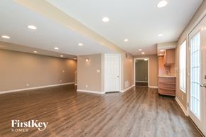 O'fallon house for rent - A spacious room with wooden floors and a white door.