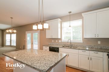 O'fallon house for rent - A kitchen with granite countertops and white cabinets.
