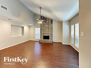 Spring house for rent - A spacious room with a fireplace and wooden flooring.