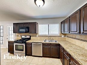 Spring house for rent - A kitchen with brown cabinets and a granite countertop.