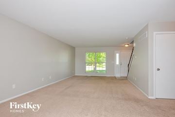 O'fallon house for rent - a spacious living room with white carpet and a window