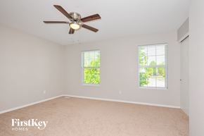 O'fallon house for rent - a bedroom with a ceiling fan and two windows