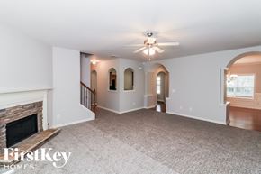 Dallas house for rent - a living room with a fireplace and a ceiling fan