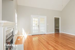 Garner house for rent - a living room with a fireplace and a door to a room with wood floors