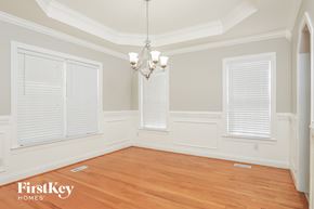 Garner house for rent - a dining room with a wood floor and a chandelier