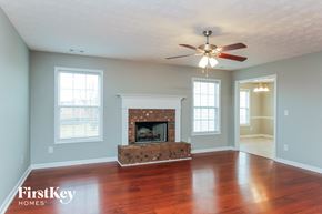 Covington house for rent - a living room with a fireplace and a ceiling fan