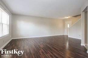Greenwood house for rent - the spacious living room with wood flooring and white walls