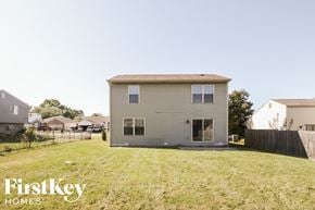 Greenwood house for rent - the back of a house in a backyard with a grassy yard