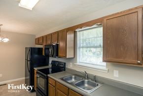 Rockmart house for rent - a kitchen with black appliances and wooden cabinets