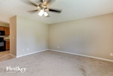 Rockmart house for rent - a living room with carpet and a ceiling fan