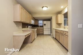 Brownsburg house for rent - a large kitchen with wooden cabinets and white appliances