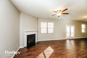 Dallas house for rent - a living room with a fireplace and a ceiling fan