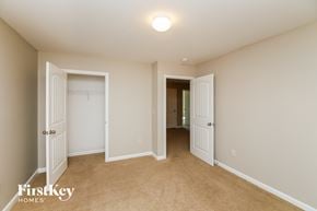 Dallas house for rent - a master bedroom with two closets and a carpeted floor and two doors to