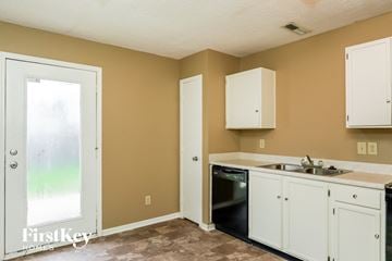 Greenwood house for rent - A kitchen with a black oven and white cabinets.