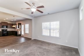 Cartersville house for rent - A spacious living room with a ceiling fan and a television.