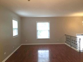 Streamwood house for rent - an empty living room with a hard wood floor and a staircase