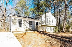 Stockbridge house for rent - the front of a white house with a driveway and trees