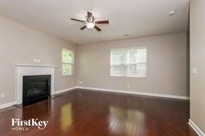 Charlotte house for rent - a living room with a ceiling fan and a fireplace