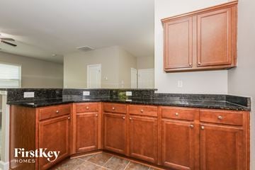 Charlotte house for rent - a kitchen with wooden cabinets and granite counter tops