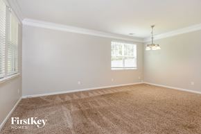 Dallas house for rent - an empty living room with carpet and a window